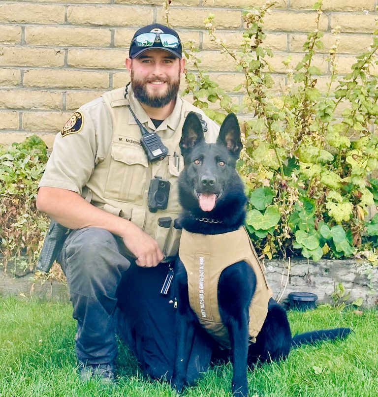 K-9 Handler Deputy Mendisco with K-9 Voodoo, a black German Shepard in his new vest.